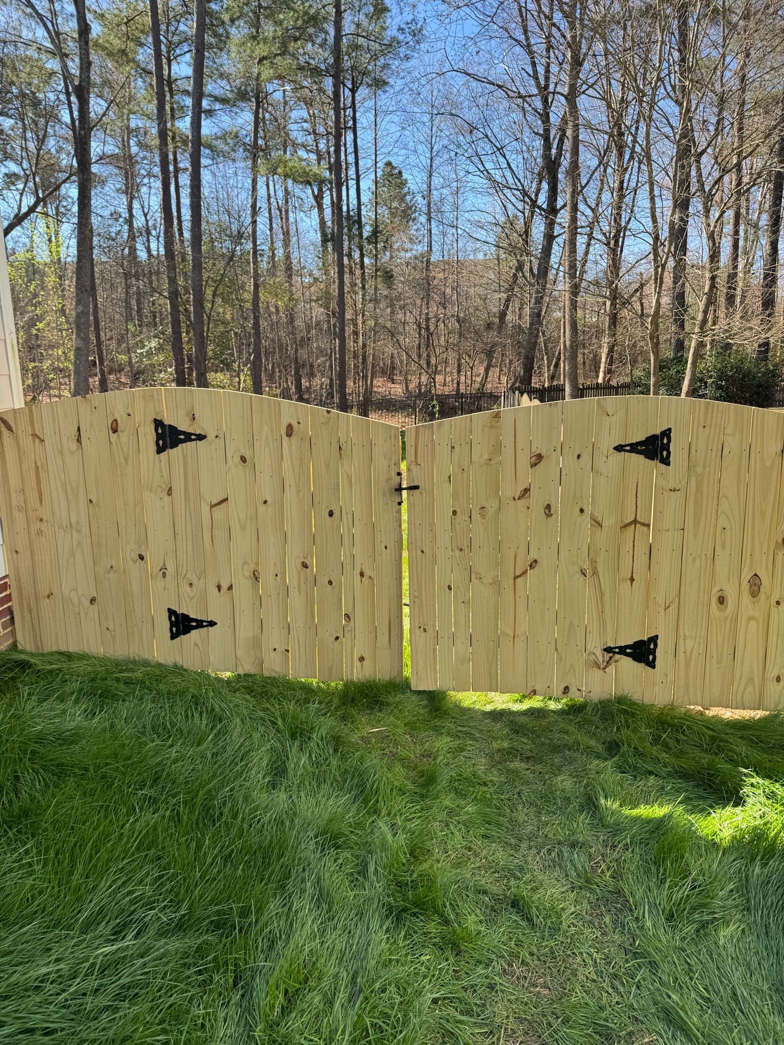 A wooden fence is sitting in the middle of a lush green field.