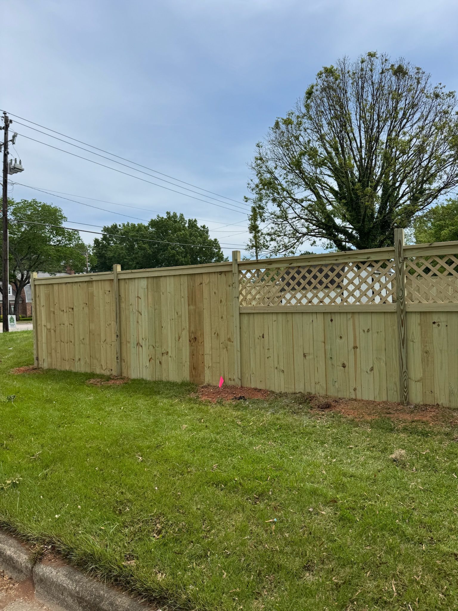 A wooden fence is sitting in the middle of a lush green field.