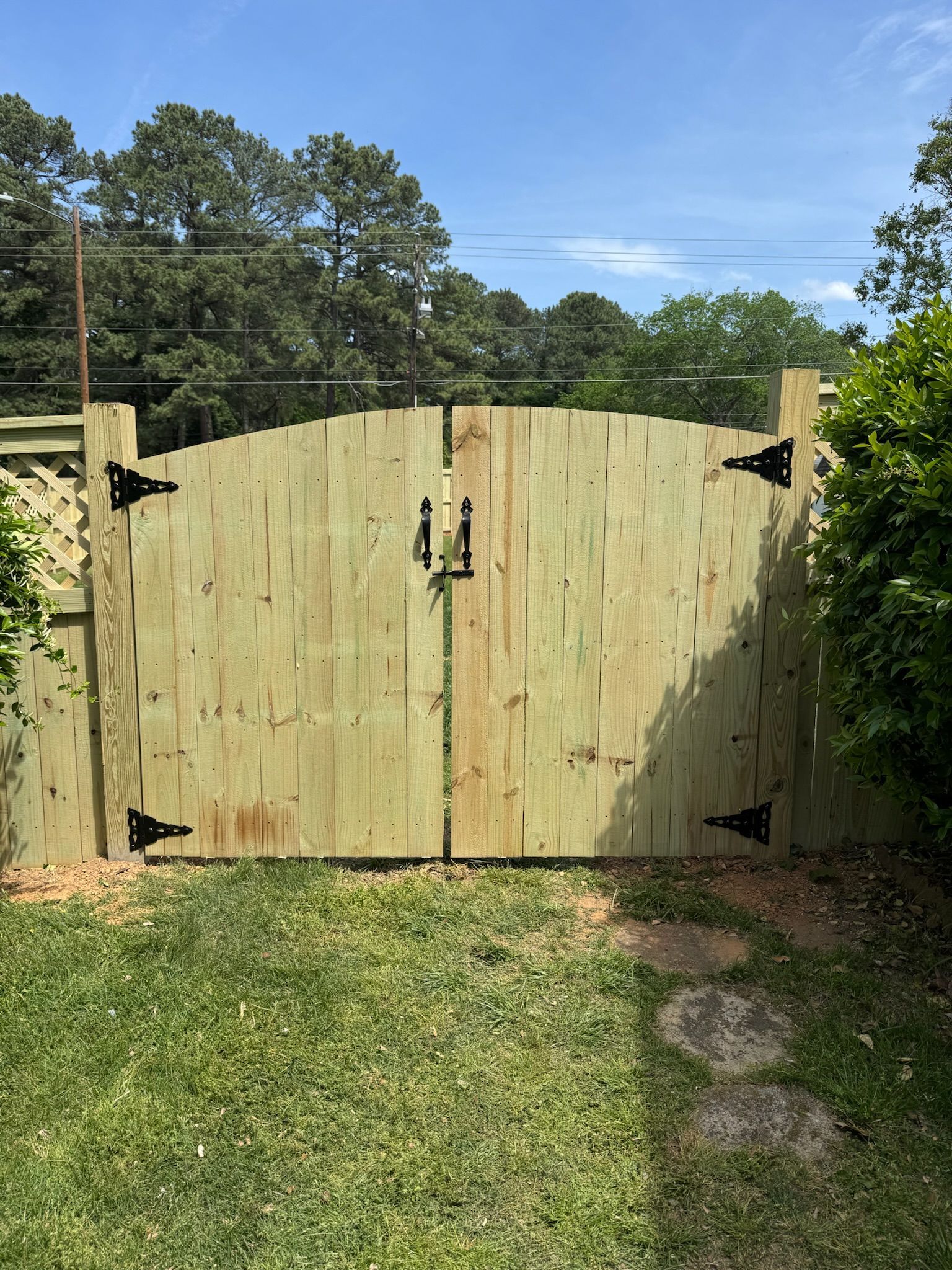 A wooden gate is sitting in the middle of a lush green field.