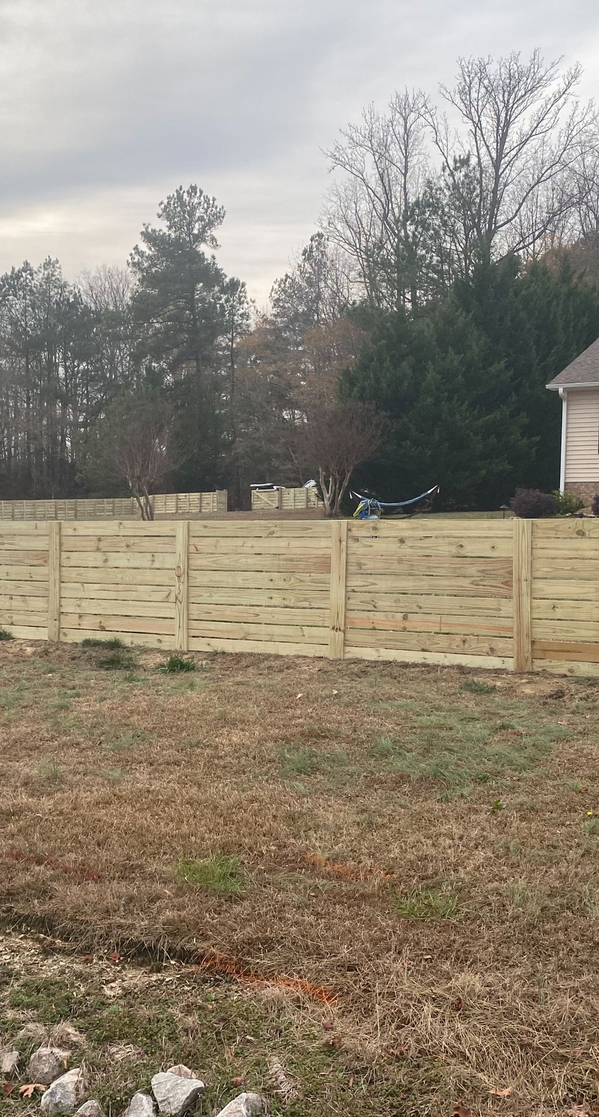 There is a wooden fence in the middle of a field.