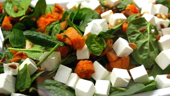 A close up of a vegetable salad with feta cheese.