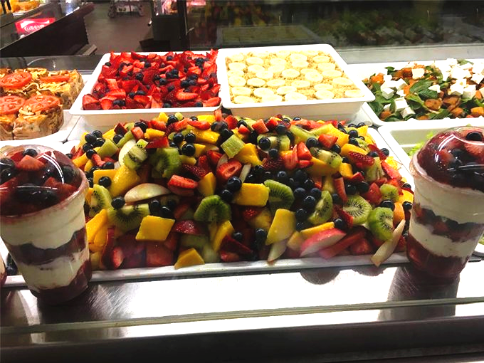 A variety of fruit salads and desserts display.