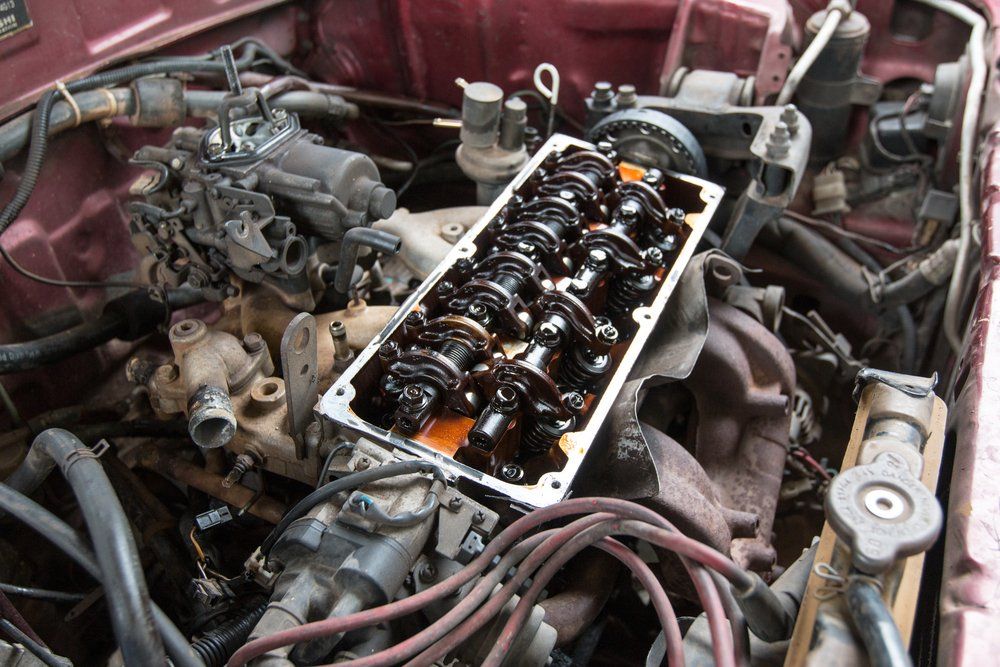 Moteur avec cache-culbuteurs retiré, laissant apparaître des composants huileux.