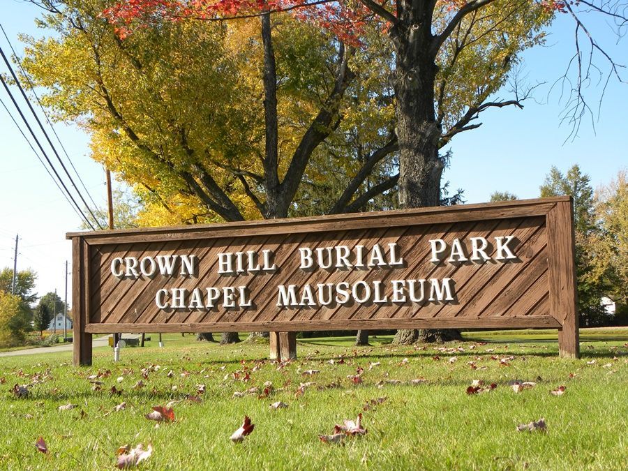 The front door of a house with a porch and plants in front of it.