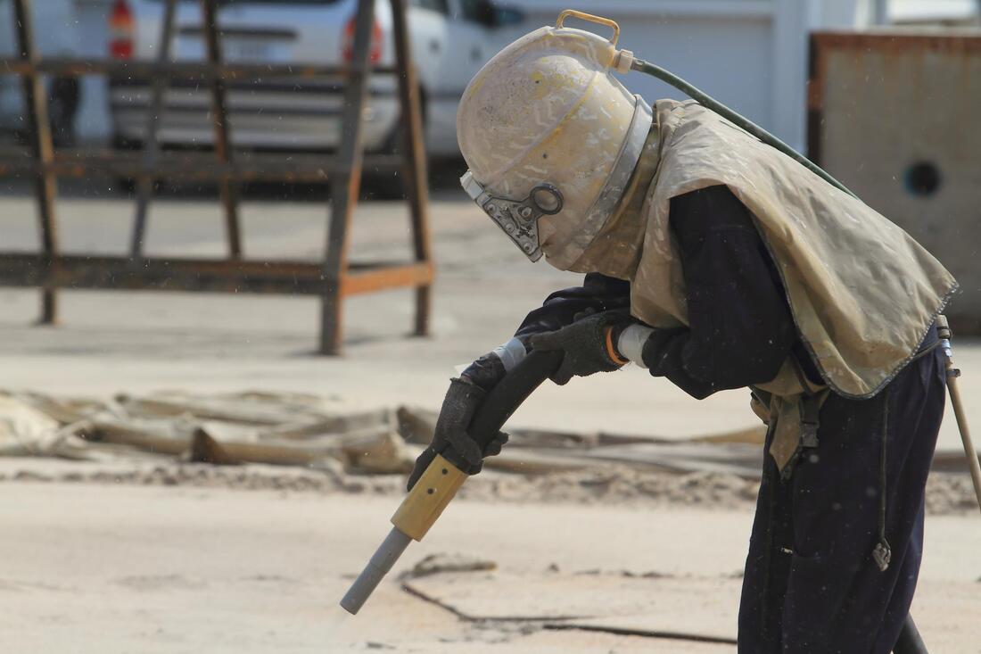 an image of worker doing dust blasting