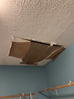 There is a hole in the ceiling in a room.
