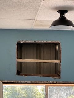 A ceiling light is hanging from the ceiling above a window.