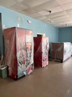 A room with a lot of vending machines wrapped in plastic.
