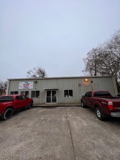 Two red trucks are parked in front of a building.