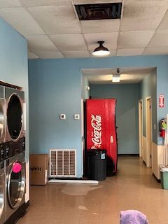There is a coca cola vending machine in the laundromat.