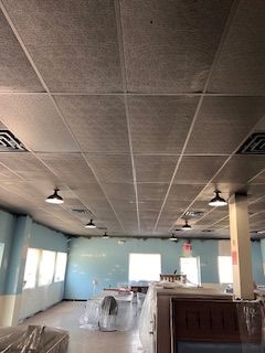 A large room with a tiled ceiling and a lot of windows.