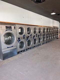 A laundromat filled with lots of washing machines and dryers.