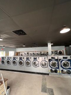 A laundromat filled with lots of washing machines and dryers.