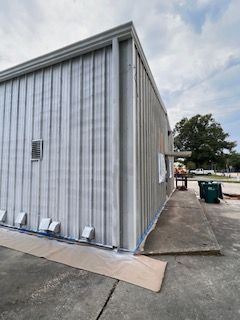 The side of a building is being painted white.