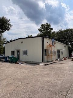 A man is standing on a scaffolding on the side of a building.