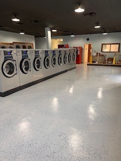 A laundromat filled with lots of washing machines and dryers.