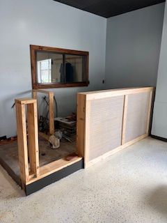 A room with a wooden divider and a window.