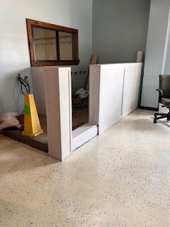 A room with a yellow cone on the floor and a chair.