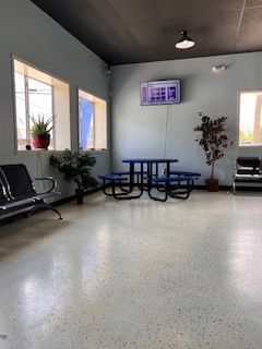 A waiting room with a picnic table and chairs