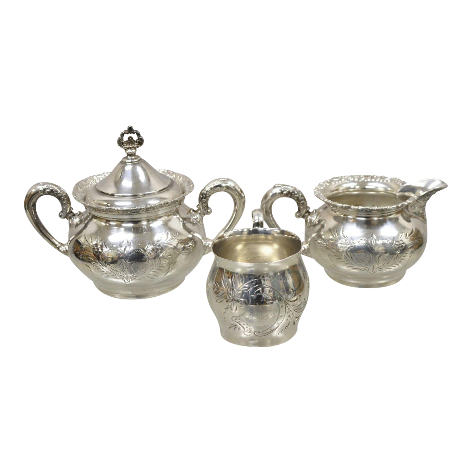 A silver tea set with a sugar bowl , creamer and teapot on a white background.