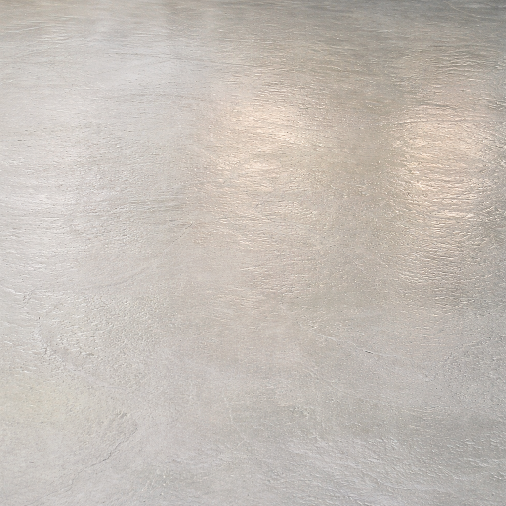 Smooth, light gray concrete floor with subtle texture and soft lighting reflections.