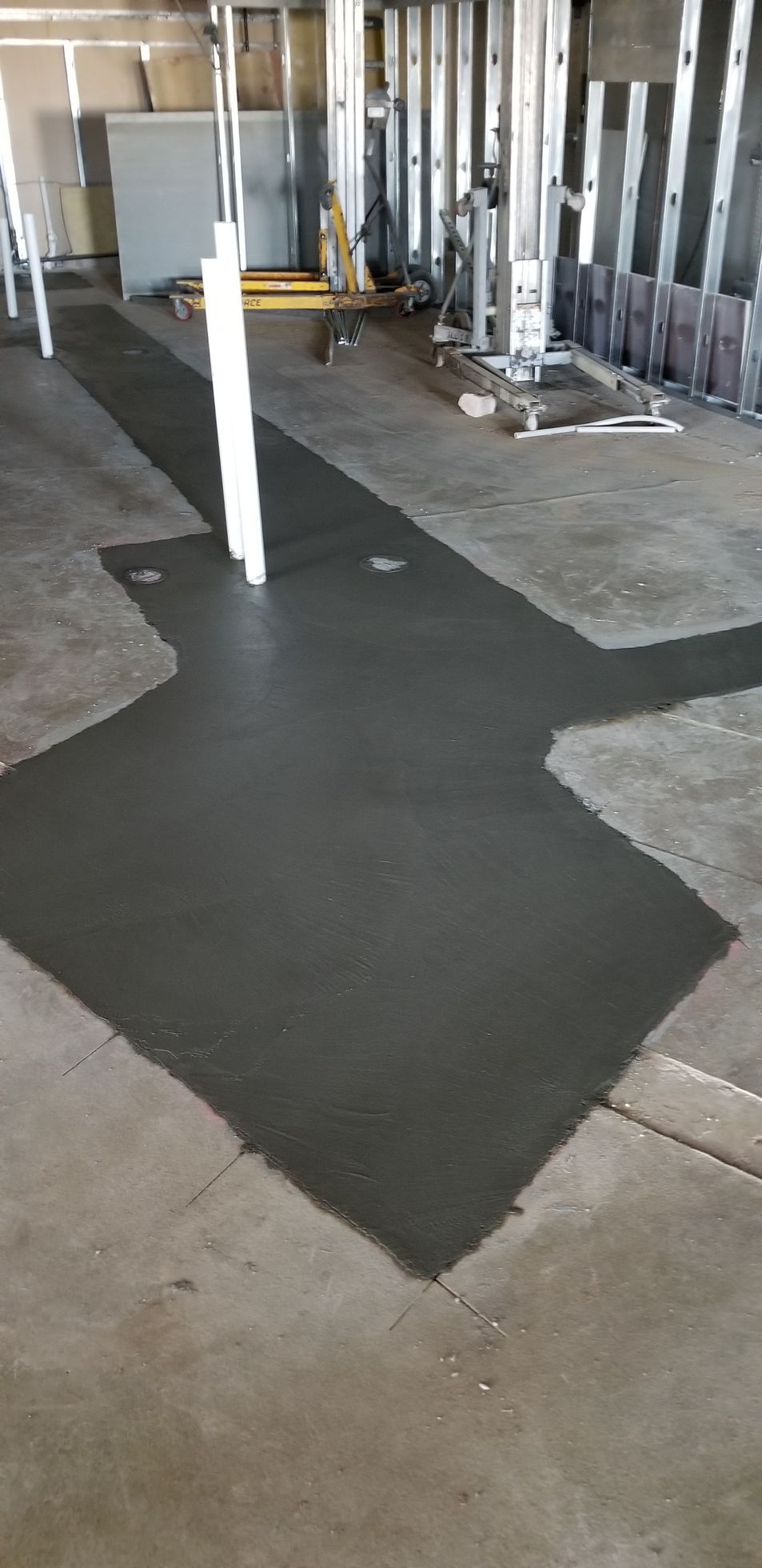 Newly poured concrete in an unfinished construction space.