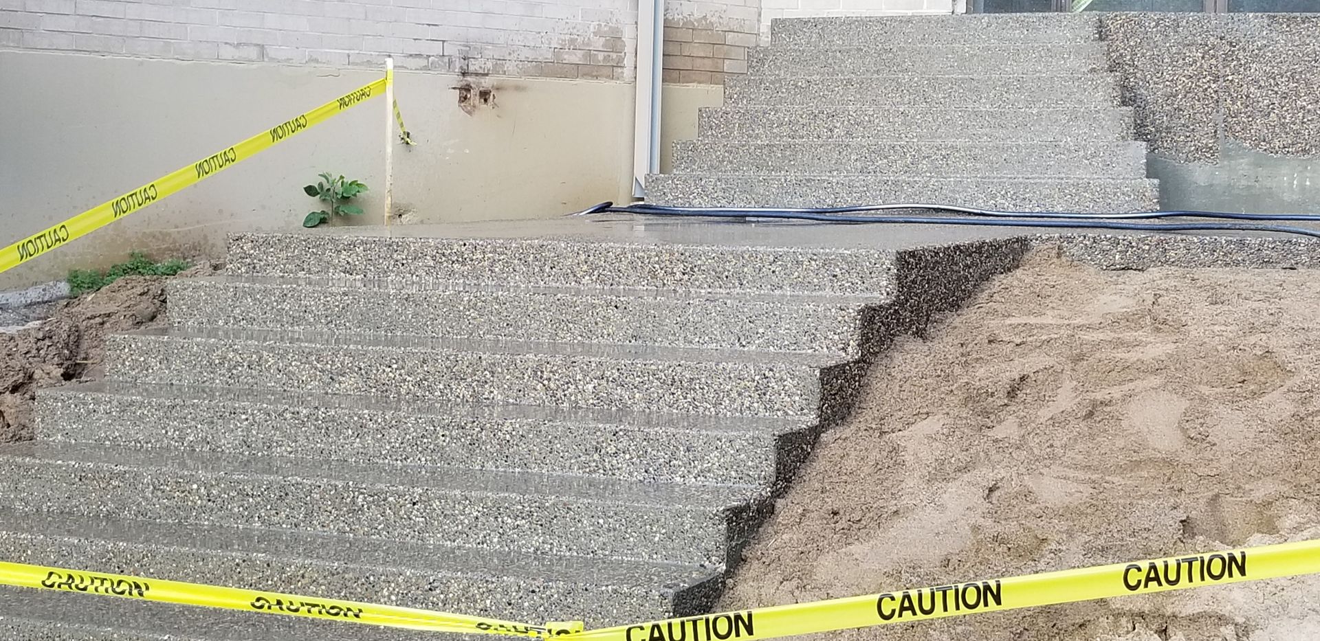 A stone staircase partially collapsed with caution tape, likely due to a washout.