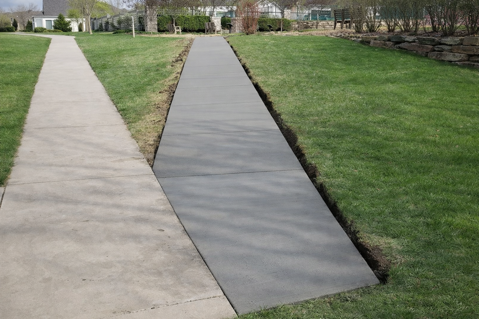 Two concrete sidewalks: one light gray, one dark gray, separated by grass.