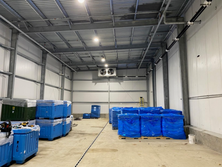 A large warehouse filled with lots of blue containers and boxes.