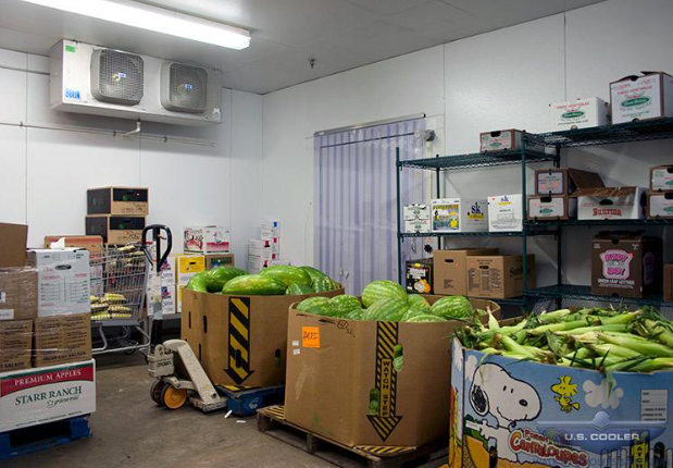 A room filled with lots of boxes of fruit and vegetables.