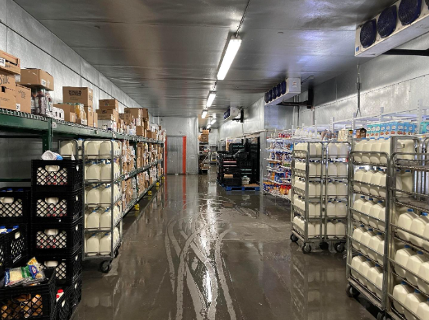 A warehouse filled with lots of milk bottles on carts.