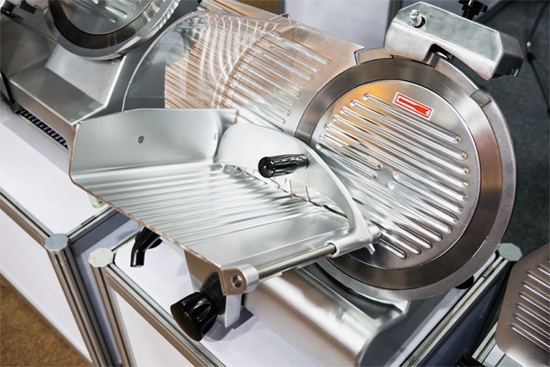 A row of refrigerators in a grocery store filled with food.