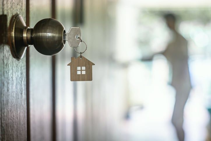 A door with a key and a house keychain on it.