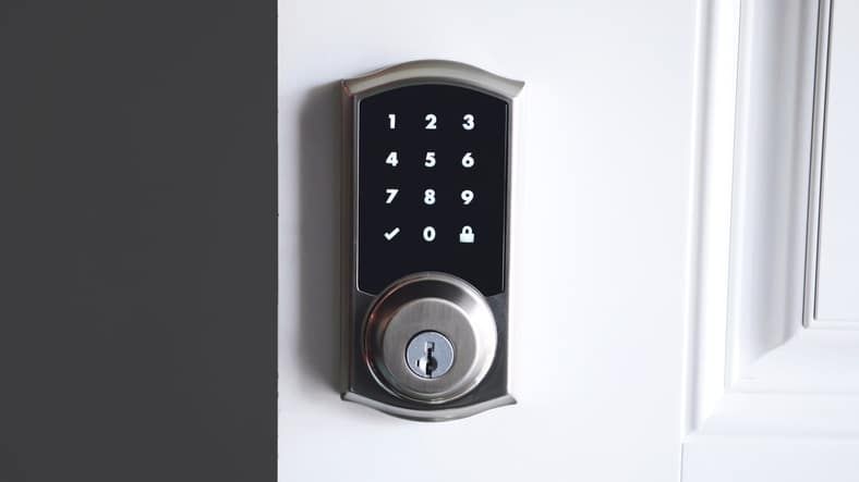 A close up of a digital door lock on a white door.