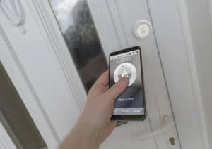 A person is holding a cell phone in front of a door.