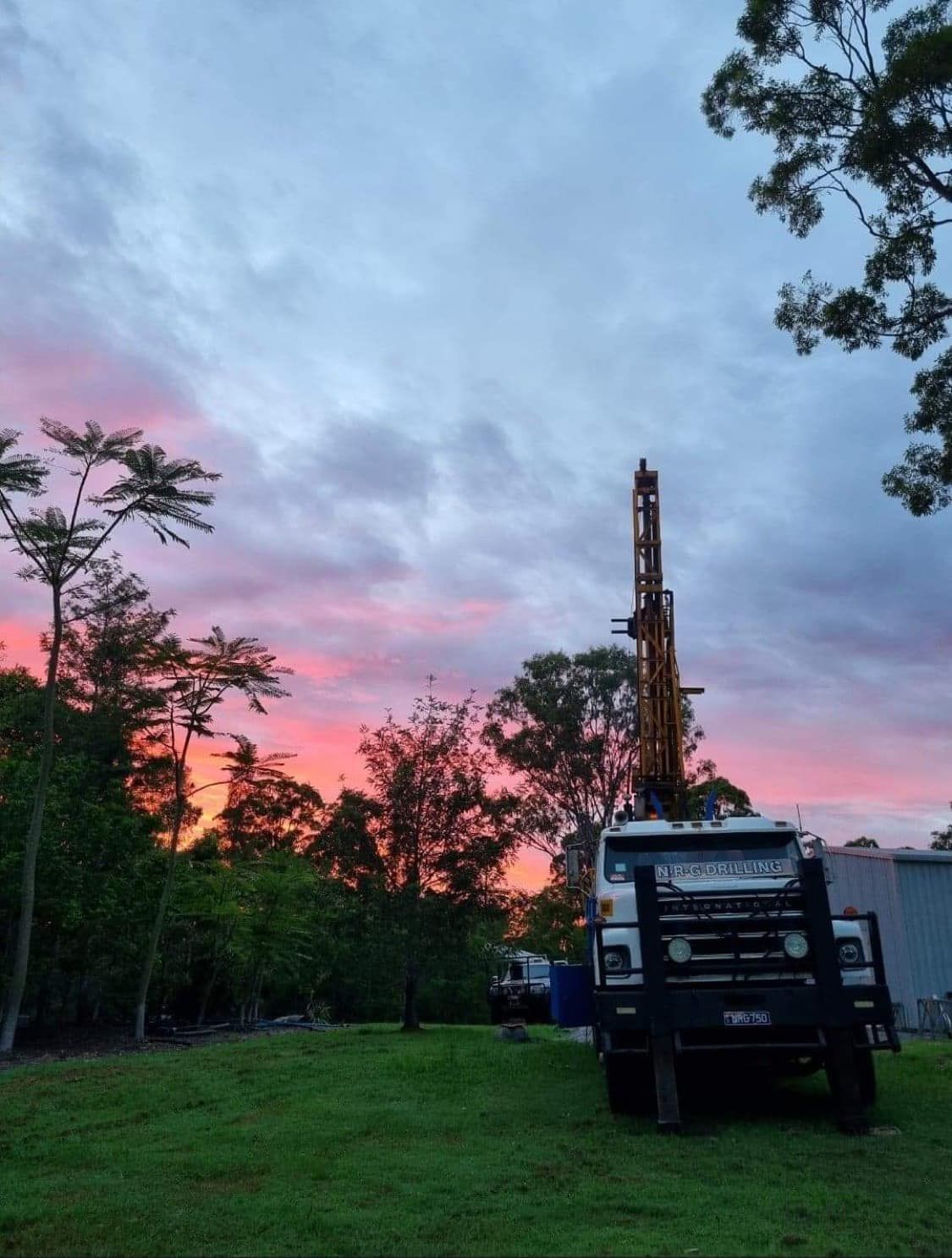 Drilling Rig in a Grassy Area Under a Colorful Sunset — NRG Drilling in Calico Creek, QLD