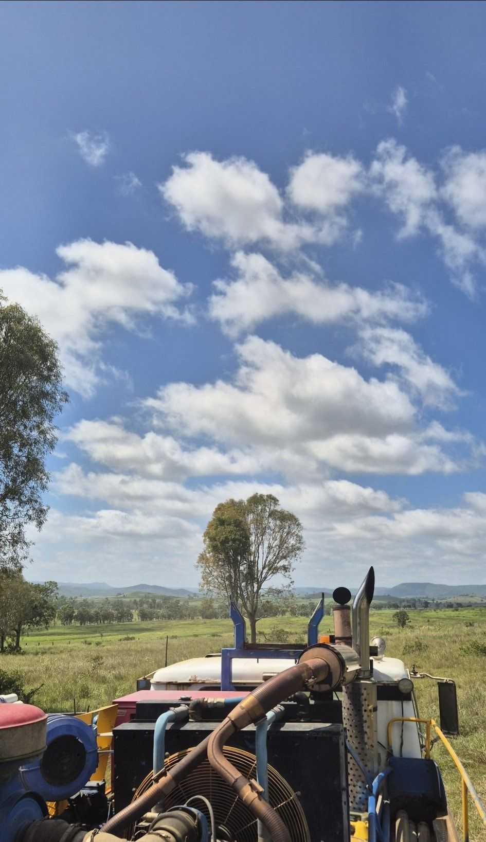 Tractor in a Field Under a Bright Blue Sky With Fluffy Clouds — NRG Drilling in Sunshine Coast, QLD