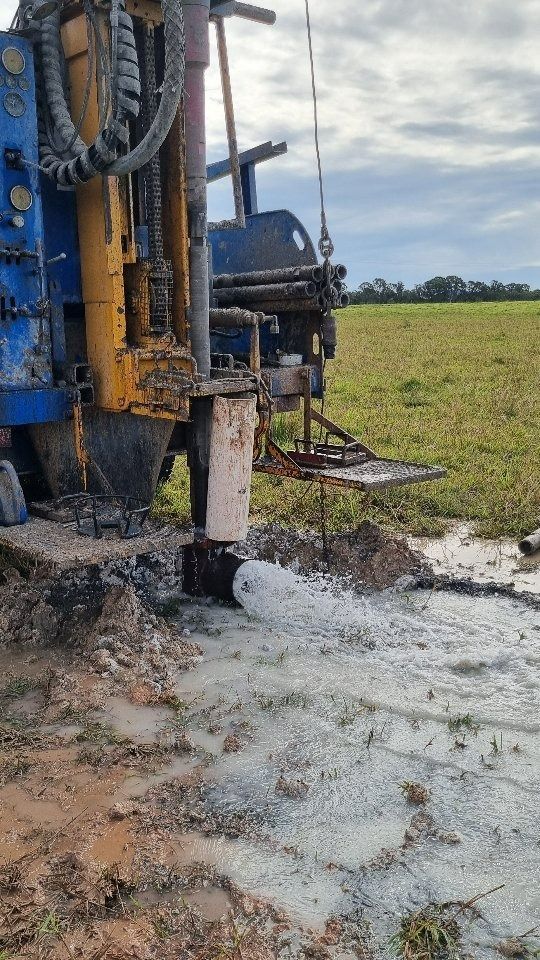 Drilling Rig in Muddy Field, Water Spraying — NRG Drilling in Calico Creek, QLD