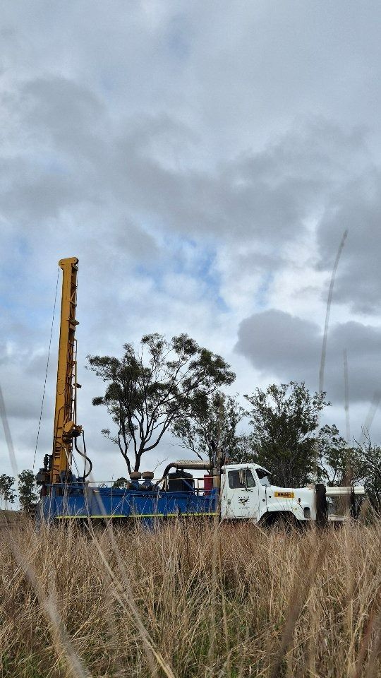 Drilling Rig on a Truck in a Field With Tall Grass — NRG Drilling in Calico Creek, QLD