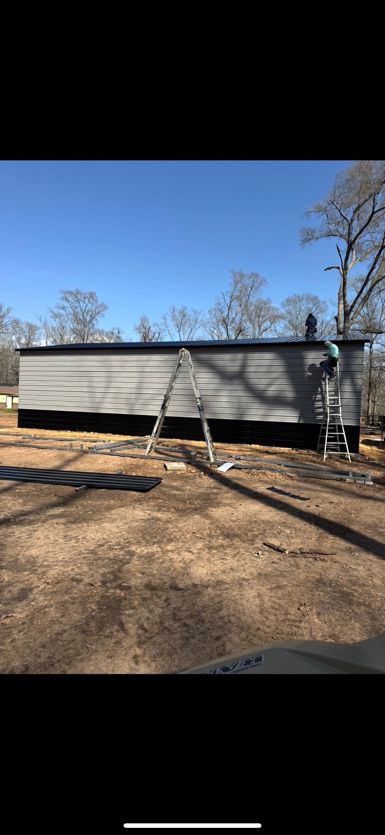 A mobile home is being painted in a field.
