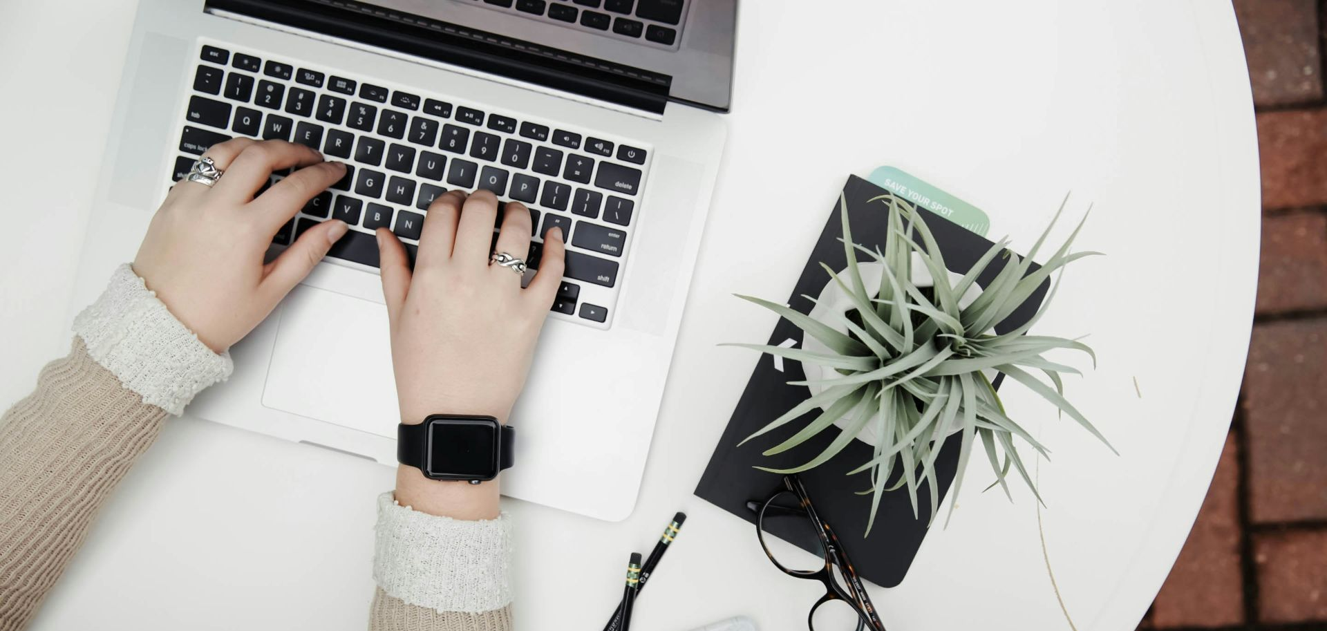 Large foyer with round wooden table, chandelier, and a vase of flowers.