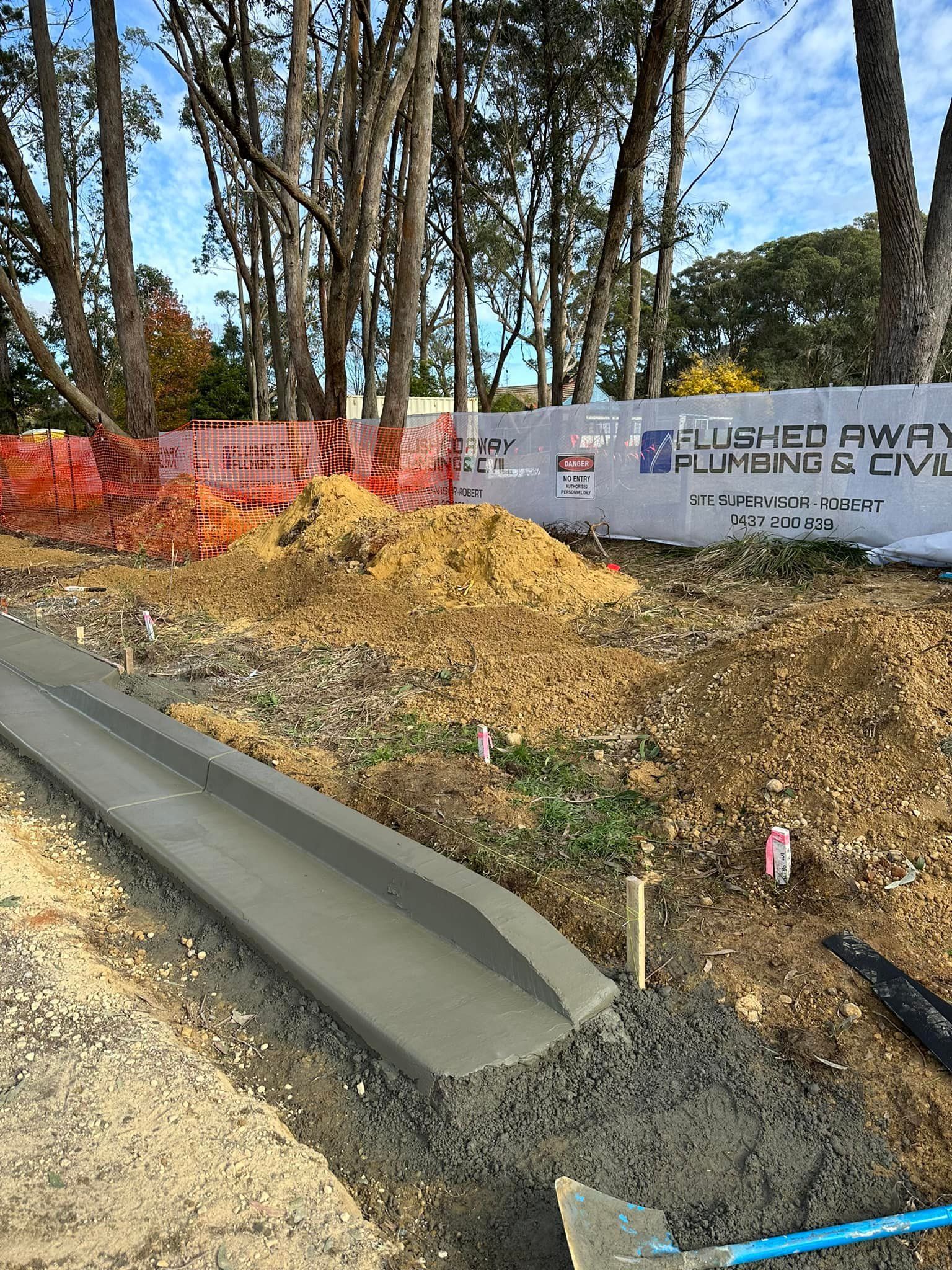 Construction site with a freshly poured concrete curb. Flushed Away Plumbing in Bowral