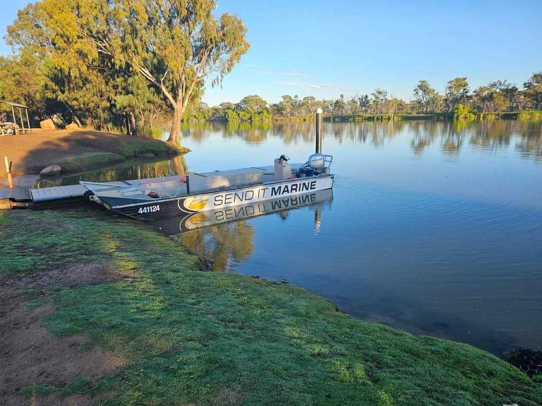A boat is docked at a dock on the shore of a lake.