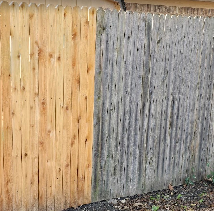 A wooden fence is being stained next to a unstained fence.