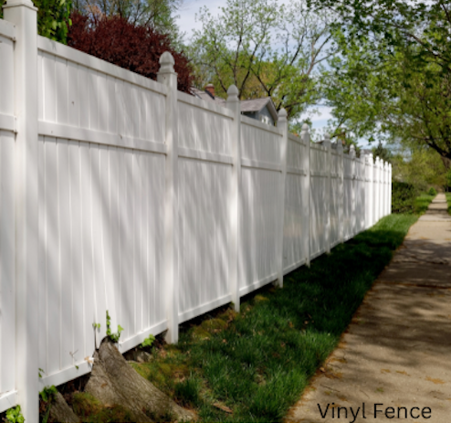 A long white vinyl fence along a sidewalk