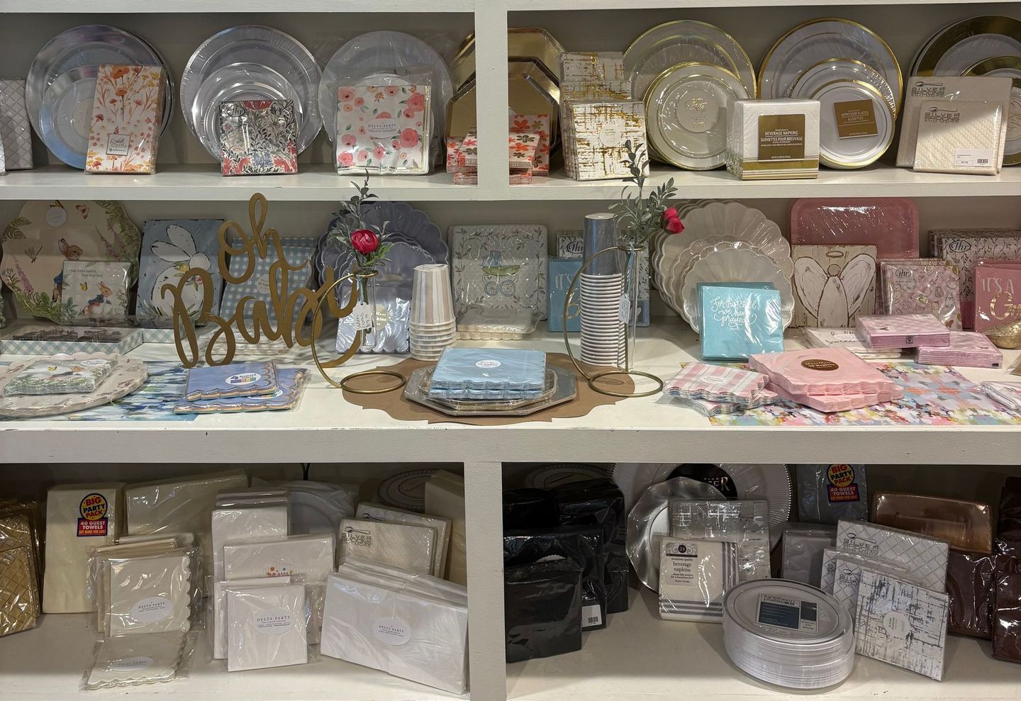 Shelves of decorative giftware and tableware in pastel colors, including plates, trays, and boxes.