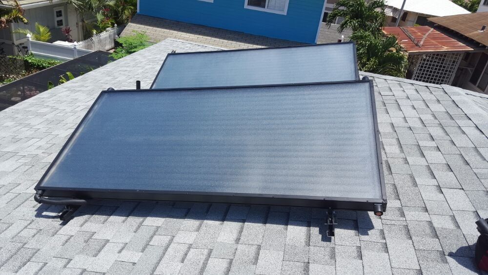 Two solar panels are sitting on top of a roof