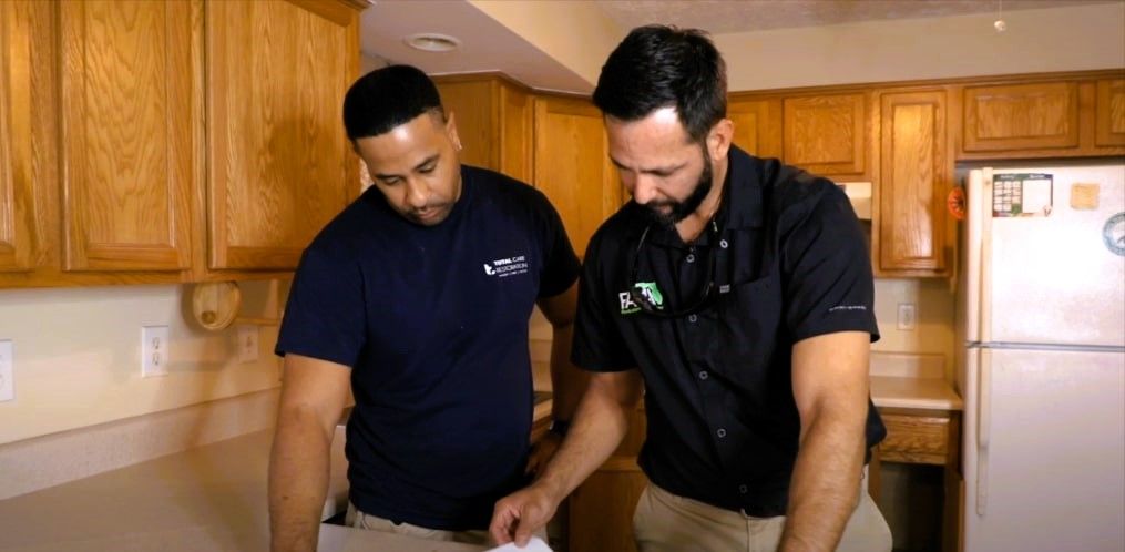 Two men in a kitchen discussing mold remediation details