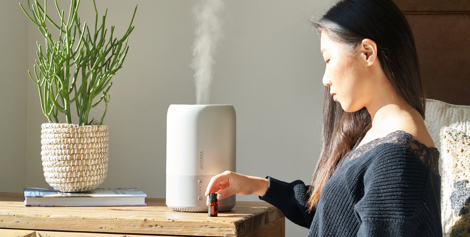 woman adds essential oil to home humidifier