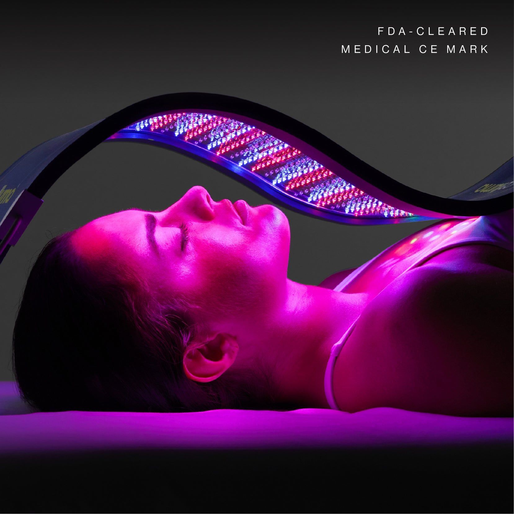 Woman under red and blue LED Celluma light therapy device. Laying down, receiving treatment.